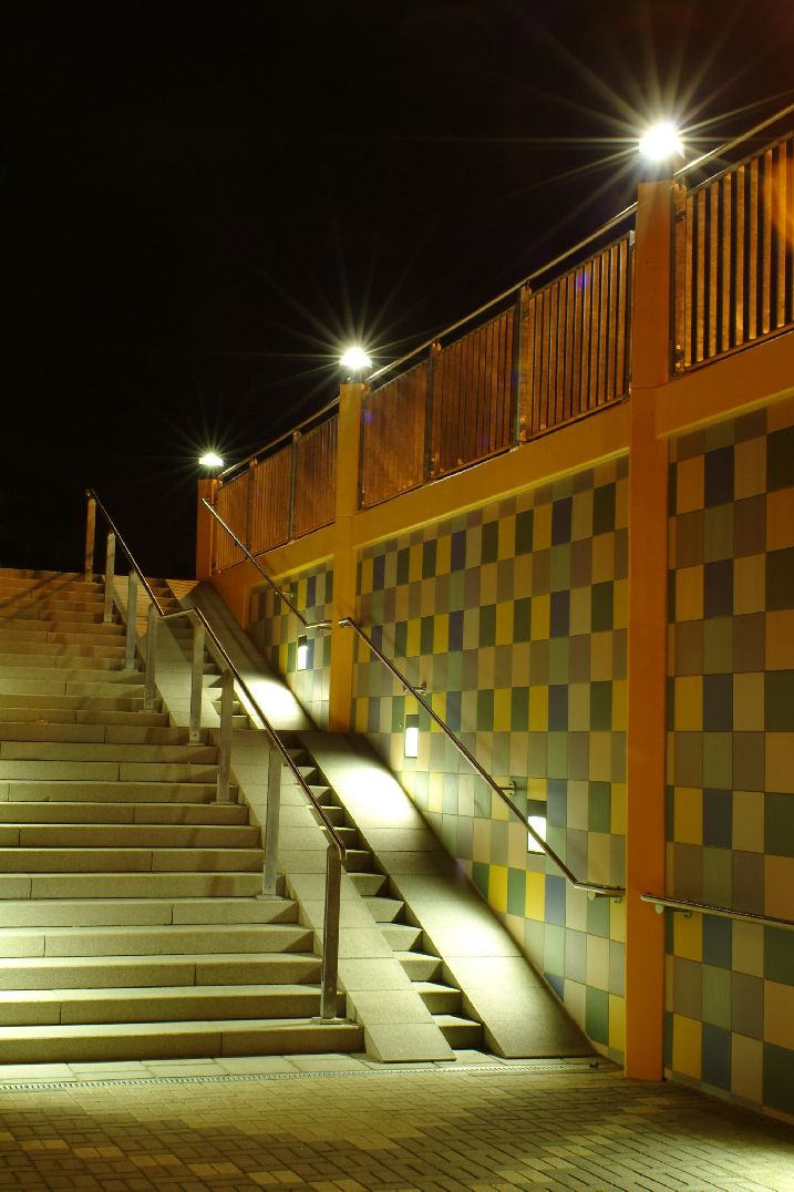 Beleuchtung eines Treppenaufgangs im Freien bei Nacht mit mehreren Lichtquellen